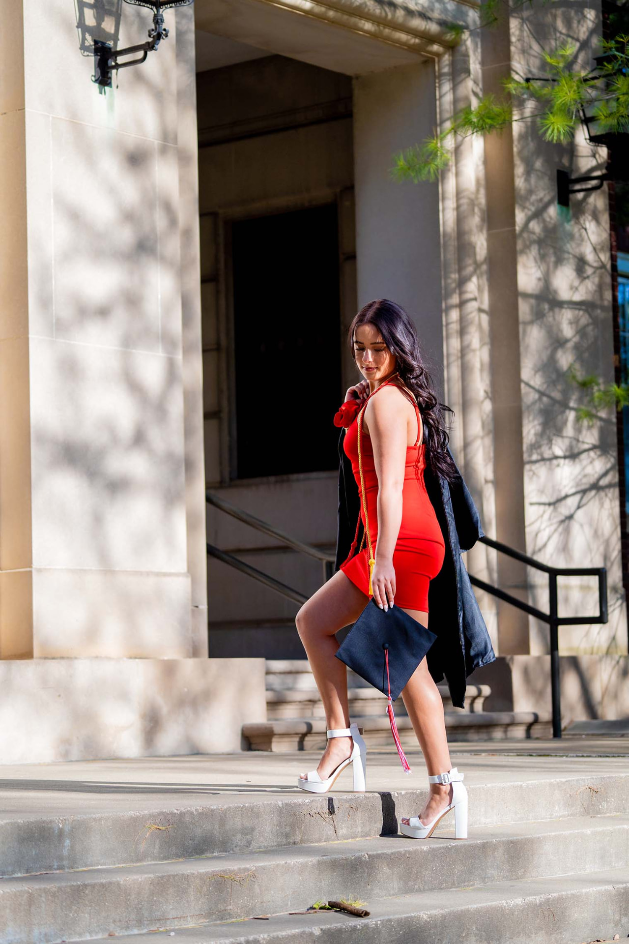 Graduate walking up the steps holding her cap
