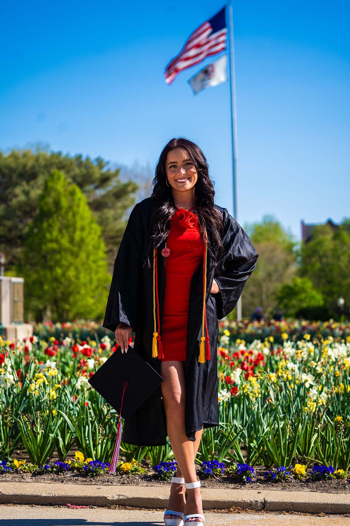 Graduate standing in front of the campus tulip beds